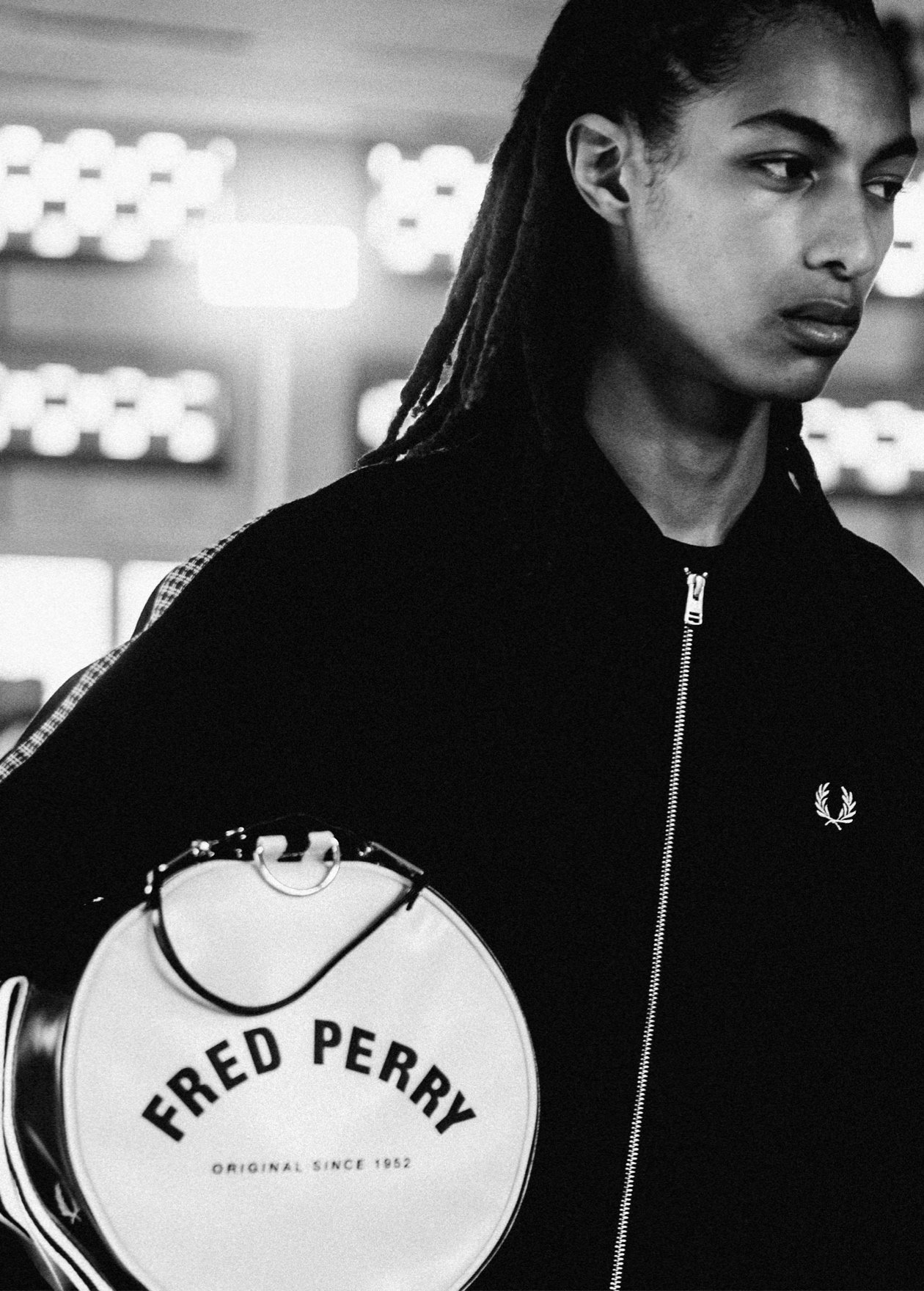 Male model walks our runway show holding the black and white barrel bag under his arm