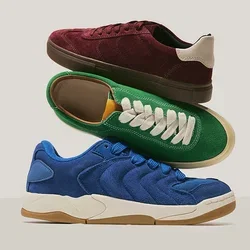 Tres zapatillas de ante apiladas en azul, verde con cordones blancos y burdeos con detalle en beige en el talón sobre un fondo neutro.