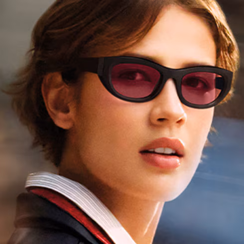 Woman wearing dark-framed glasses with Transitions Gen S lenses in ruby