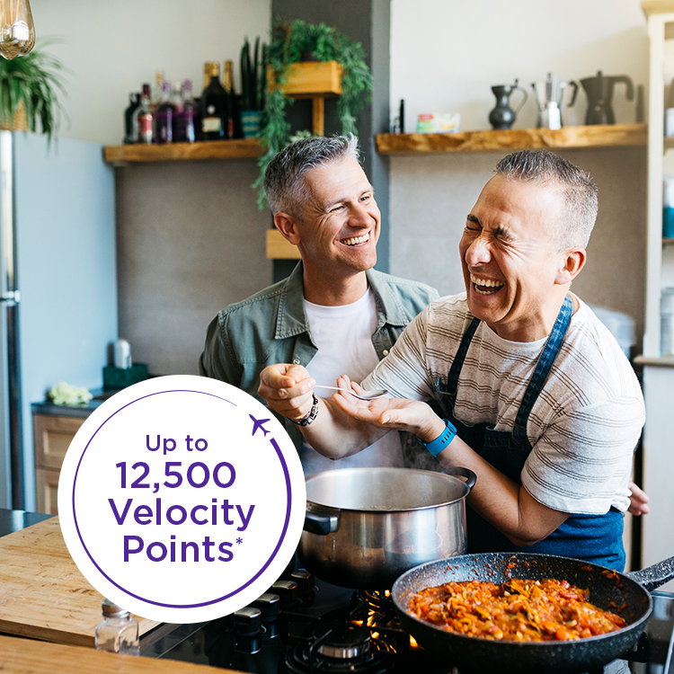Two men cooking. Text overlay: Up to 12,500 Velocity Points.