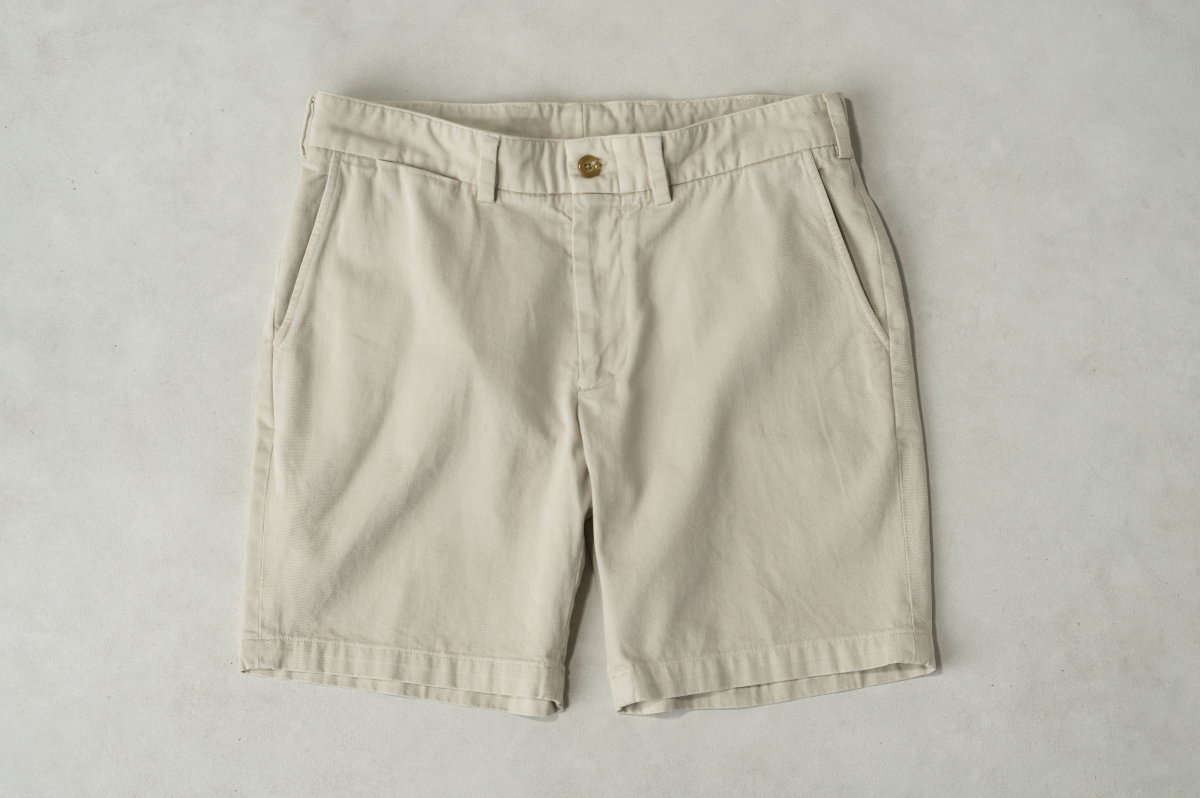 Bills Khakis Khaki shorts laying on a warm stone surface