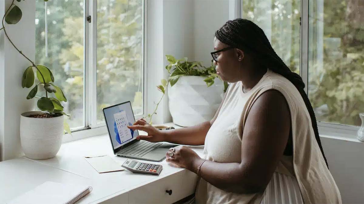 a woman sitting at a desk using a laptop