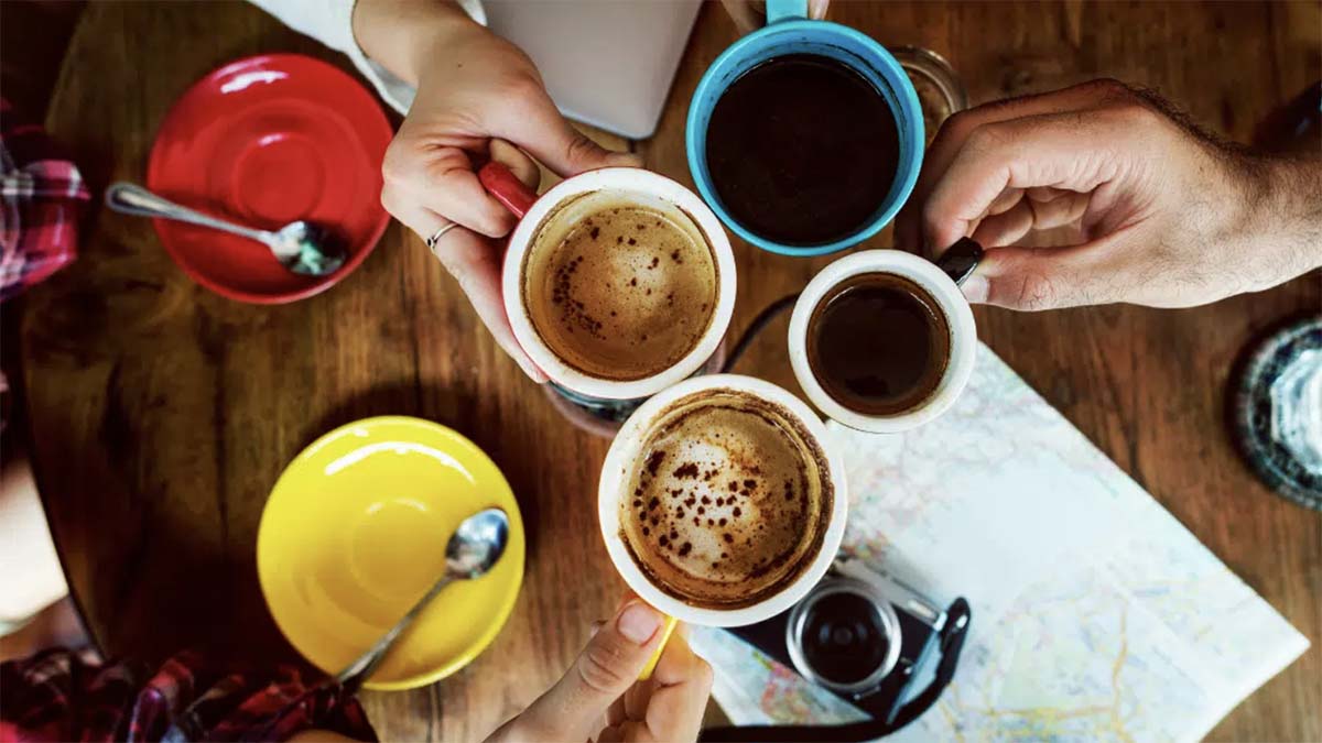 An image of a group of people clinking their mugs together