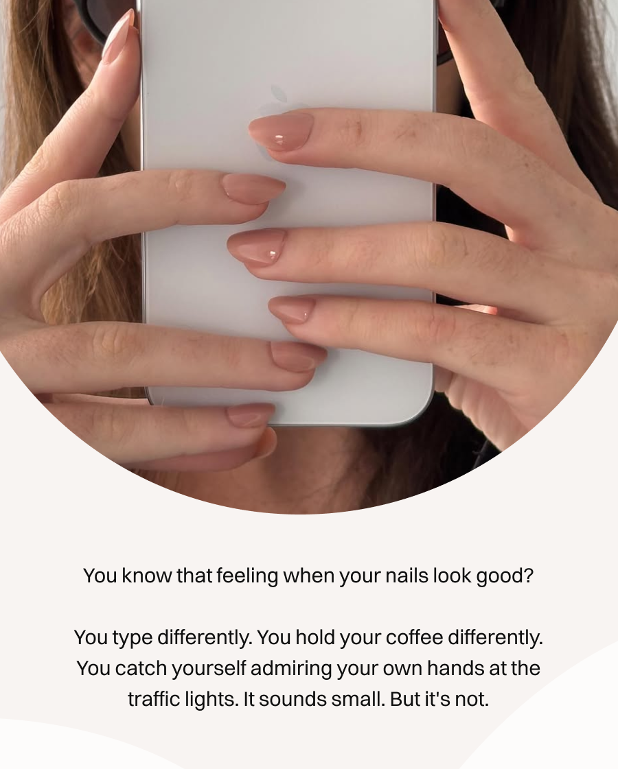 Hands with nude pink press-on nails holding an iPhone, showing natural-looking manicured fingertips