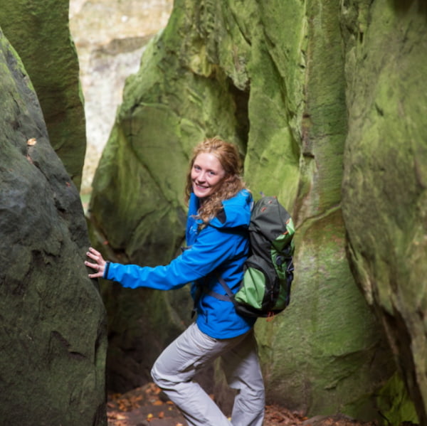 Hiker in front of a rock formation on the Mullerthal Trail