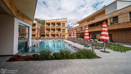 hotel mit außenpool liegen und sonnenschirmen