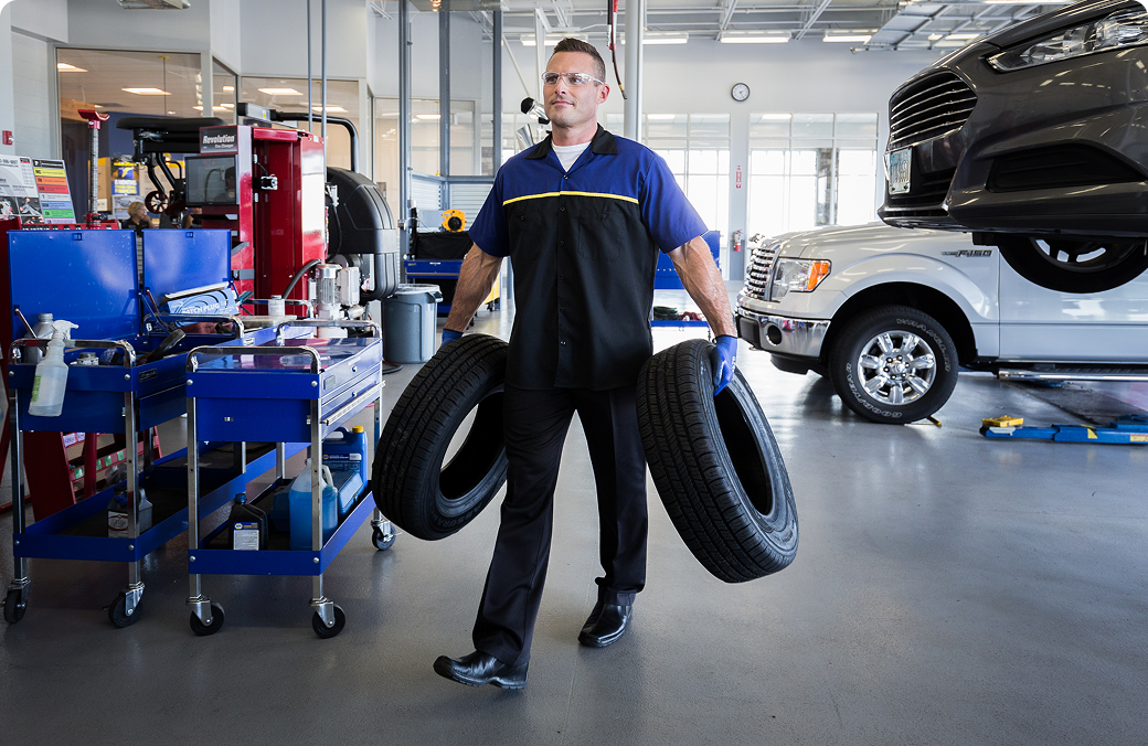 Technican carrying tires