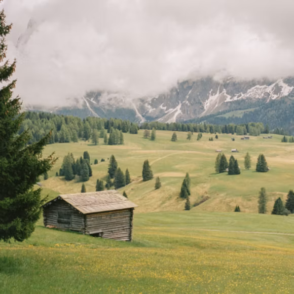 A traditional mountain hut set within the Alpe di Siusi in the Dolomites, Italy, linking to BA High Life site. 