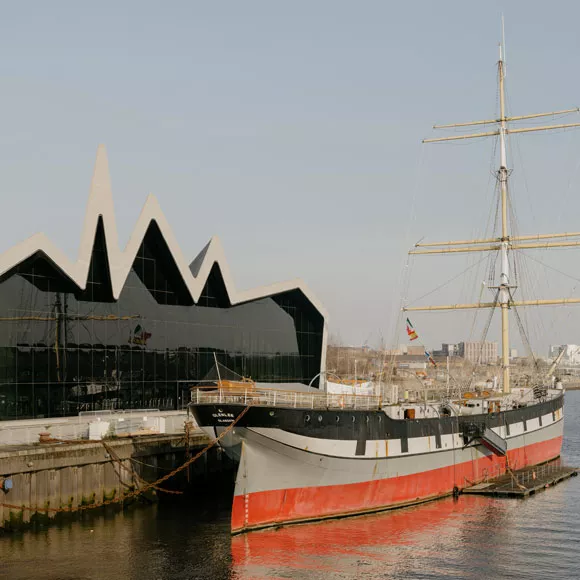 A tall ship outside the Riverside Museum in Glasgow, linking to BA High Life site.