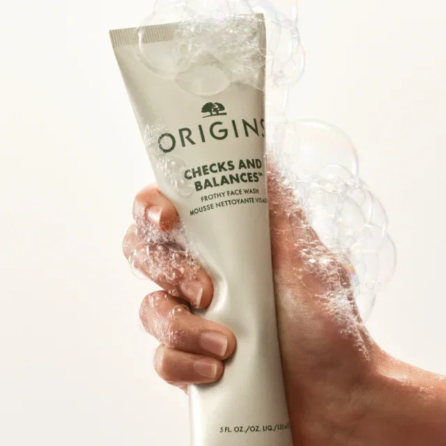 Hand squeezing a tube of Checks and Balances™  Frothy Face Wash.