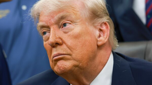 President Trump from the shoulders up in a dark blue suit. 
