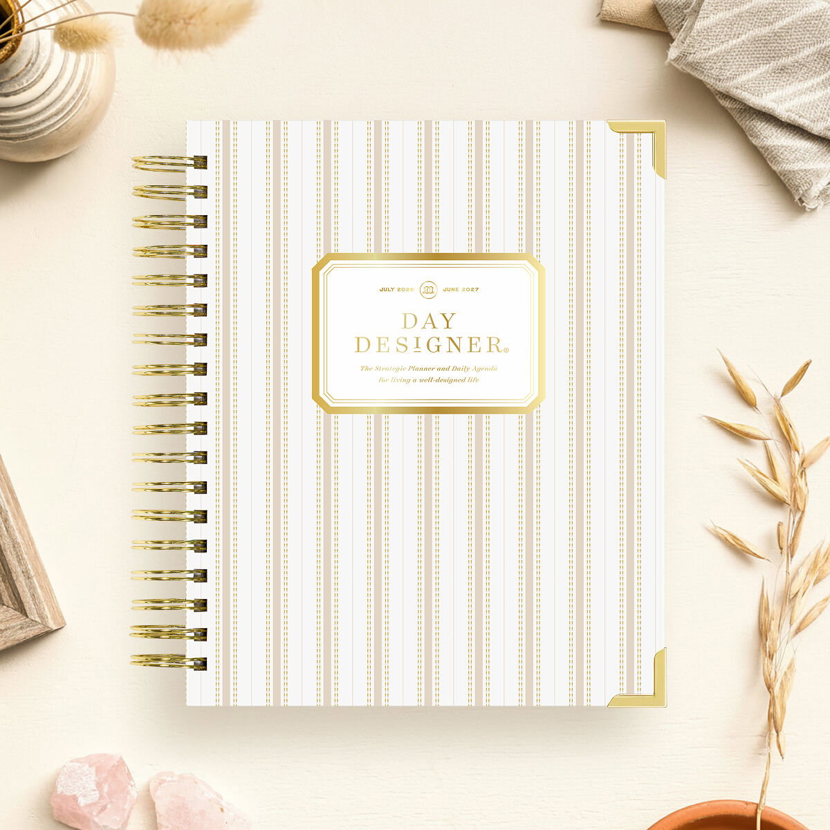 gold vertical striped day designer planner, gold binding, beige background, vase, dried wheat, cloth