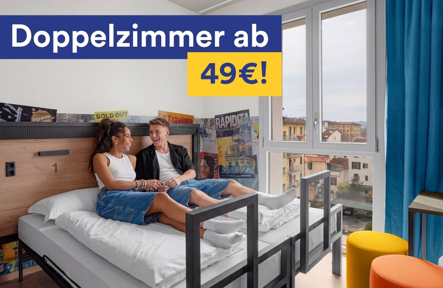 Ein Pärchen sitzt lachend auf einem Bett in einem a&o Hostel Doppelzimmer mit Stadtblick. Im Bild ist der Text „Doppelzimmer ab 49 €!" eingeblendet.