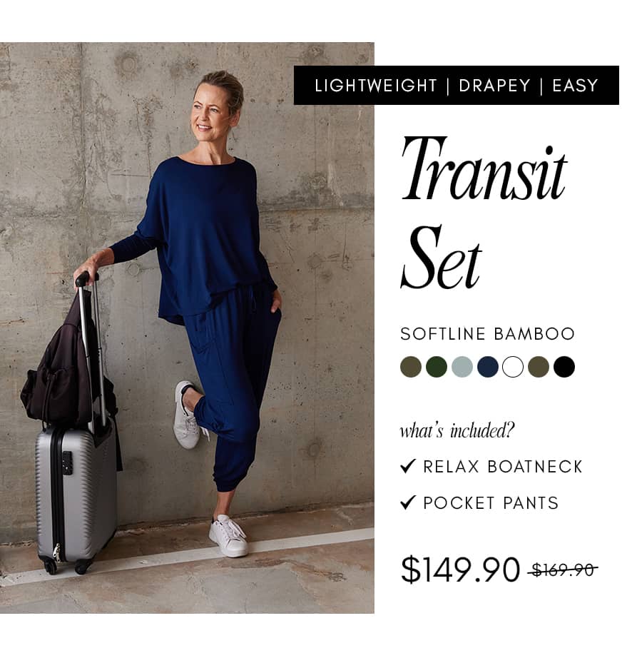 A woman stands next to a silver suitcase and a black backpack, wearing a navy blue 'Transit Set' consisting of a 'RELAX BOATNECK' top and 'POCKET PANT...
