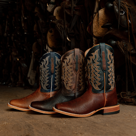 A line up of Tony Lama boots lined up in a tack room.