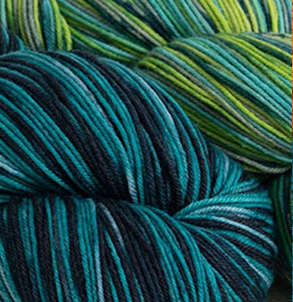 Two skeins of sock yarns in blues and greens >>