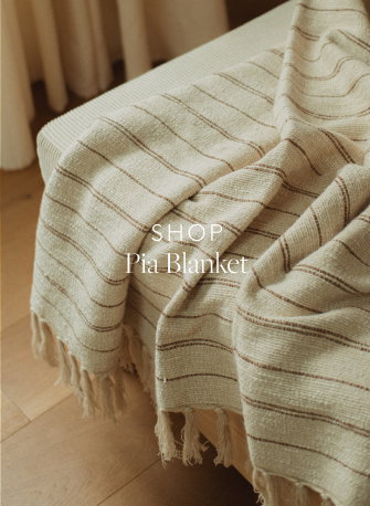 Detail of a beige blanket with brown stripes on a chair