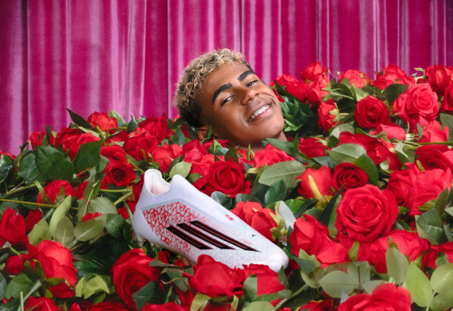 Lamine Yamal lies in a sea of roses, smiling with just his head showing next to his signature adidas F50 cleats.
