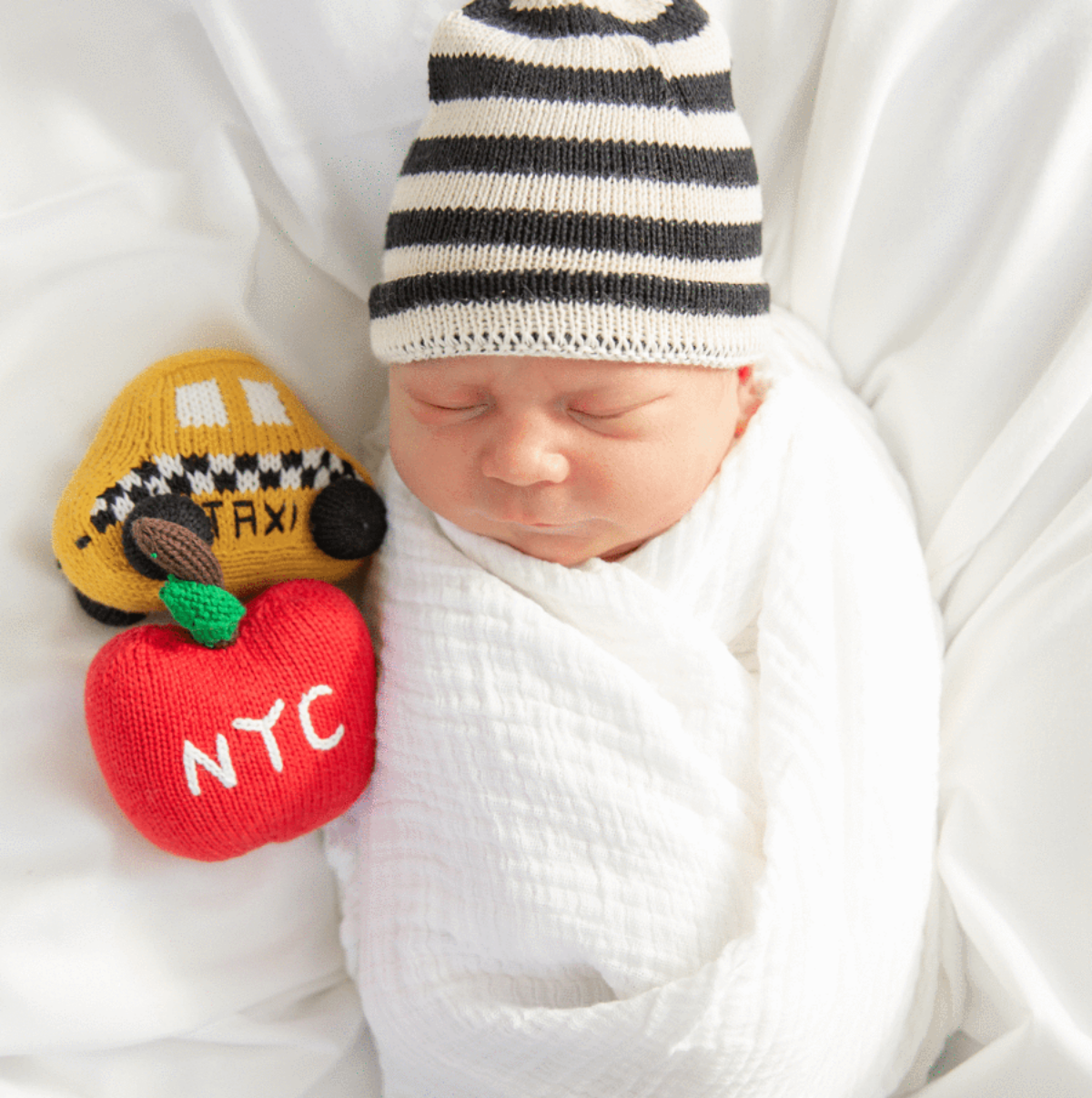 Baby New Yorker Gift Set - baby surrounded by NYC-themed organic knit toys