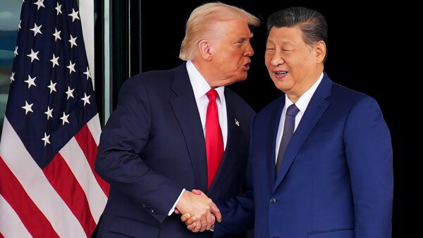 U.S. President Donald Trump and Chinese President Xi Jinping shake hands. They stand next to an American flag. 