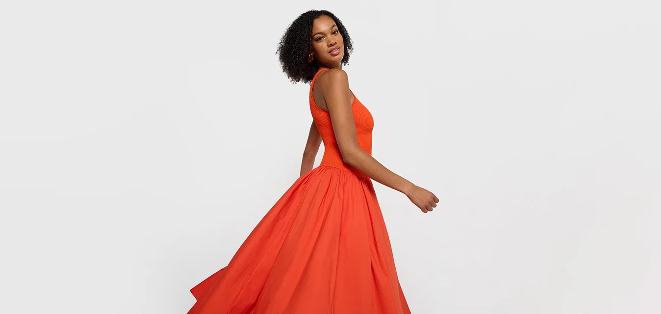 Rotes Abendkleid mit tailliertem Oberteil und vollem, fließendem Rock. Hergestellt aus leichtem Stoff, mit glatter Textur und ärmellosem Design.