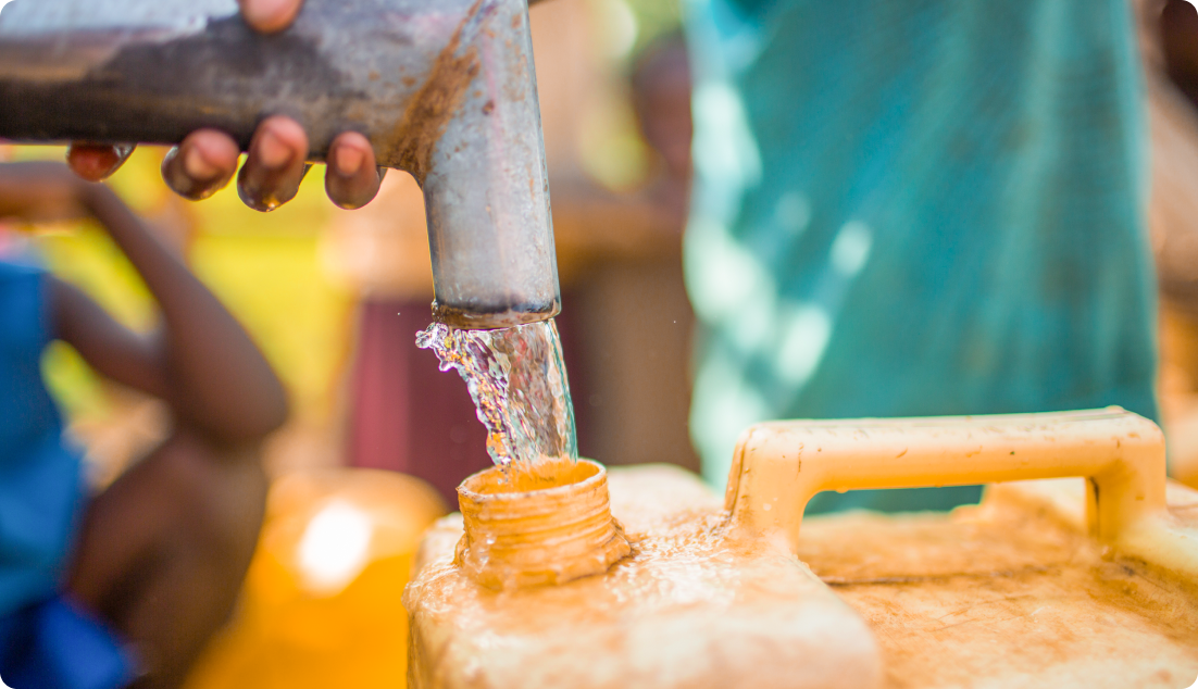 Water being poured into a yellow jerry can from a tap stand.