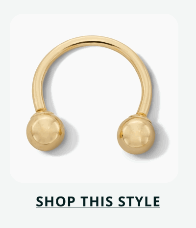 Gold horseshoe barbell, with spherical beads threaded onto ends. Click here to shop this style