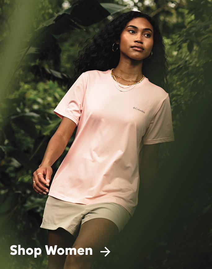A woman in a cute pink top and khaki shorts.