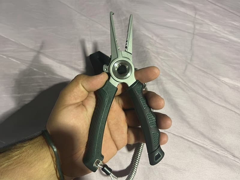 Paulina holding a fishing pliers in hand, highlighting its quality. Customer shares the product exceeded all their expectations and enhances their fishing trips.