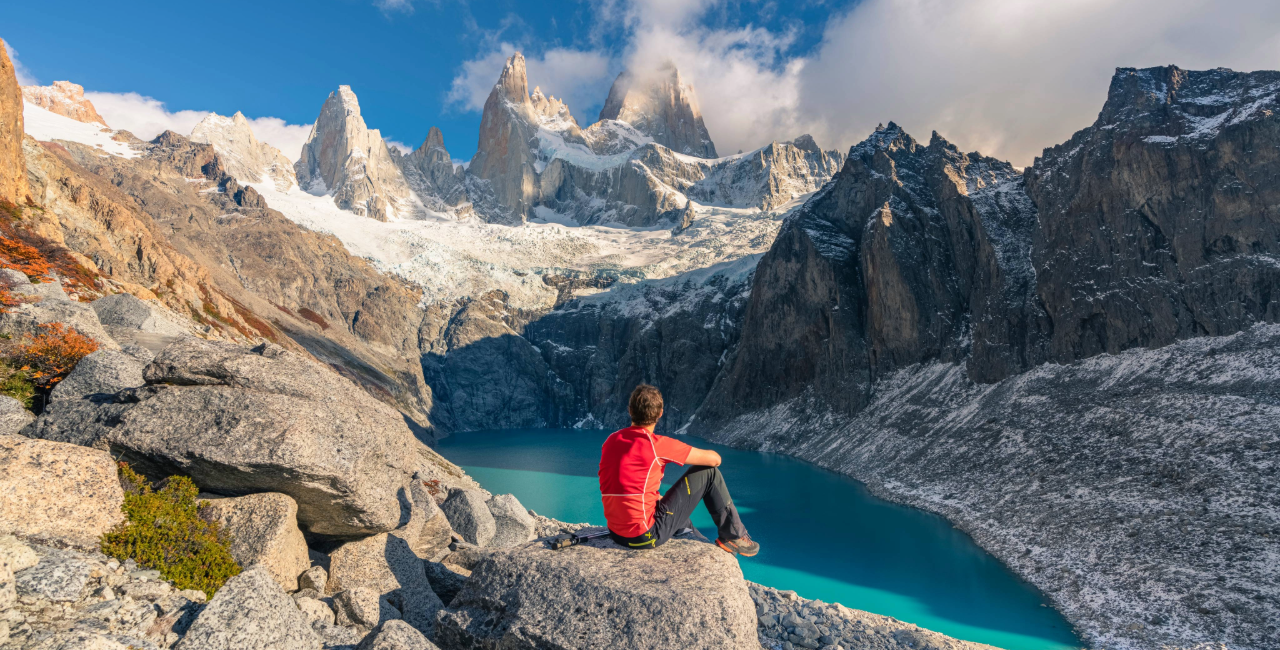 Man sitting on rocks by a lake in Patagonia