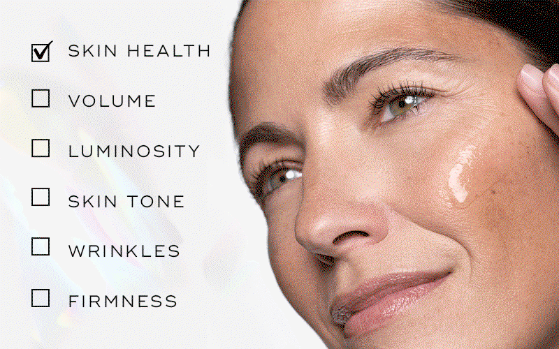 Close-up of a woman applying serum to her cheek beside a checklist of benefits including skin health, volume, luminosity, skin tone, wrinkles and firmness.