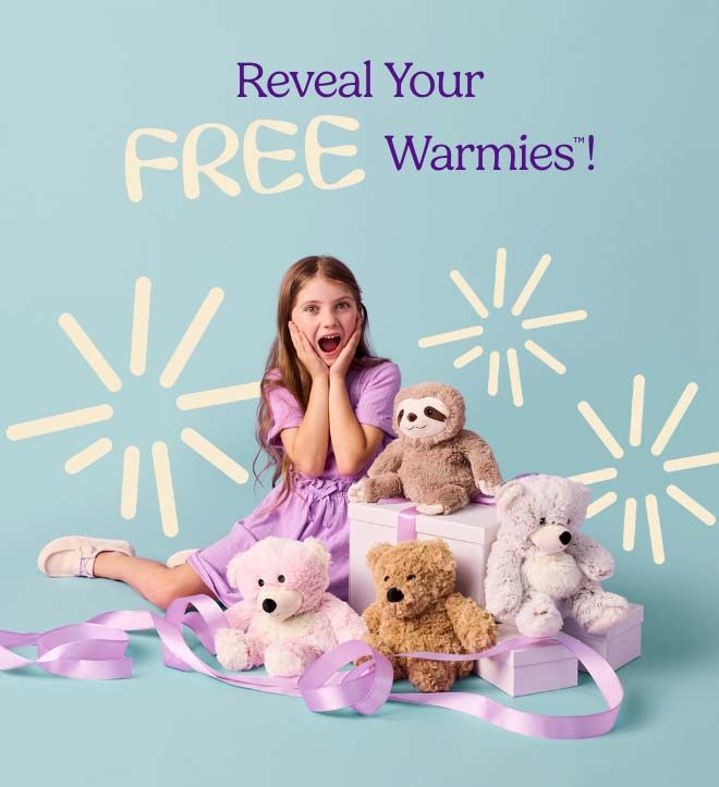 A little girl surrounded by Warmies with a suprised expression. Shop Mystery Gift.
