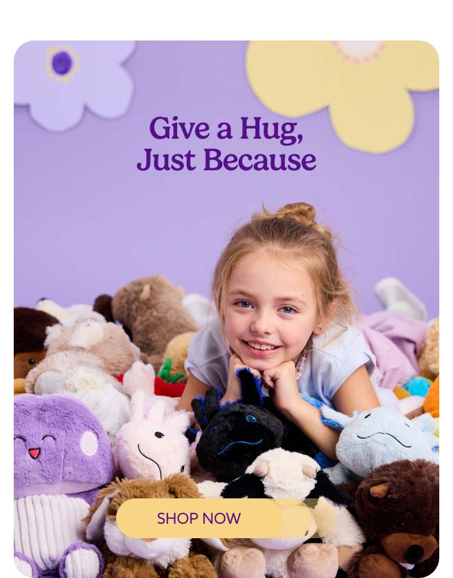 A little girl laying on a pile of Warmies. Shop Now.