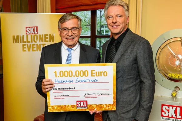 Der Gewinner des SKL Millionen-Events in Regensburg steht neben Jörg Pilawa und hält einen Scheck über 1 Million Euro in den Händen.