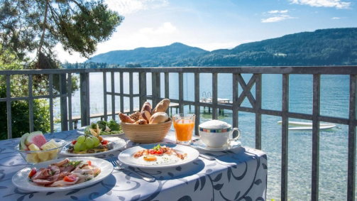 Hotel terrasse mit gedeckten frühstückstisch direkt am see