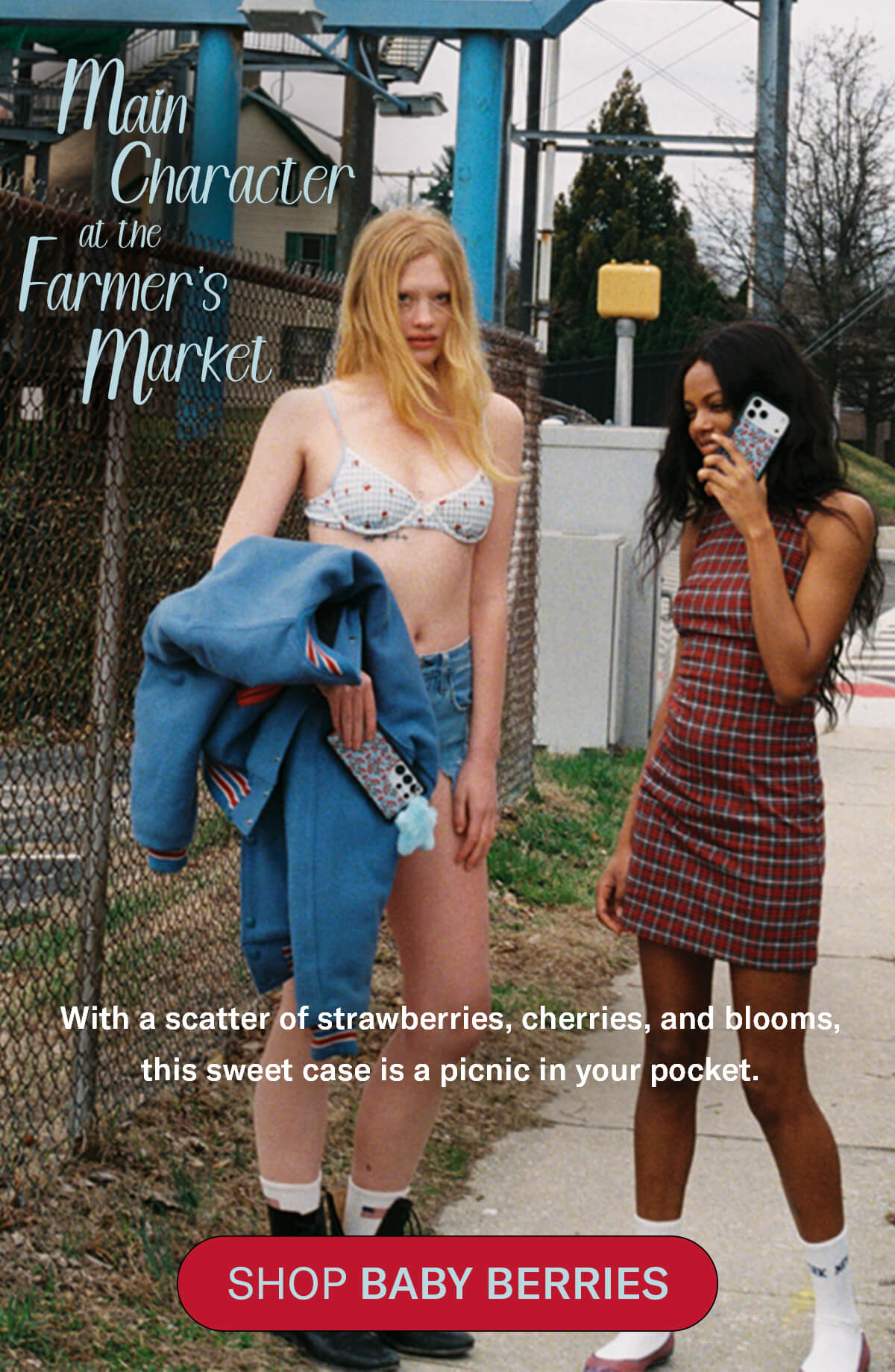 Two women walking outdoors — one in a gingham cherry bikini top with a denim jacket and the Baby Berries case, one in a red plaid dress talking on the Baby Berries case — with "Main Character at the Farmer's Market" text overlay and a Shop Baby Berries button