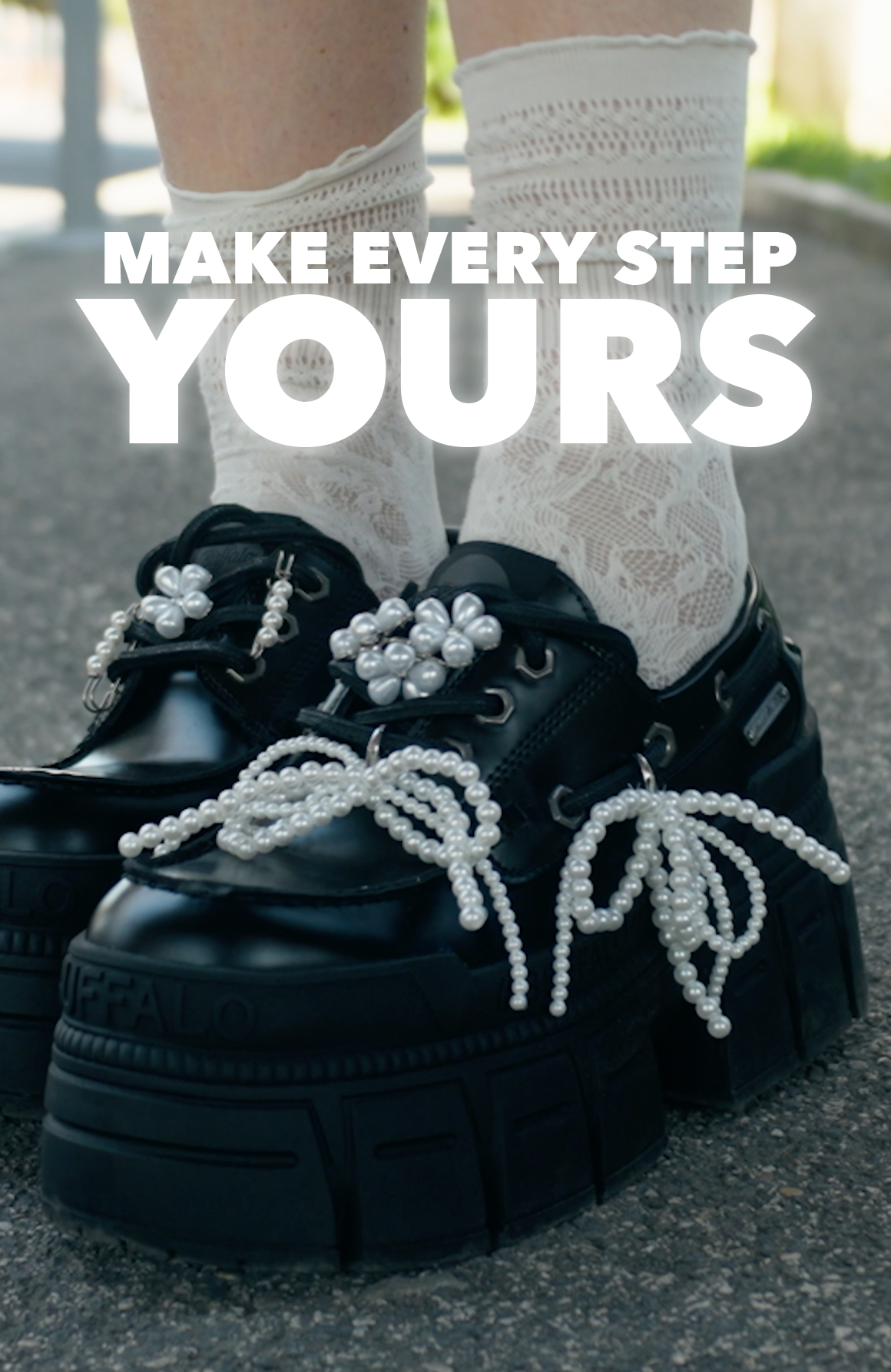 Black platform shoes with pearl details worn with white lace socks, viewed from behind, with the text ‘Make Every Step Yours’