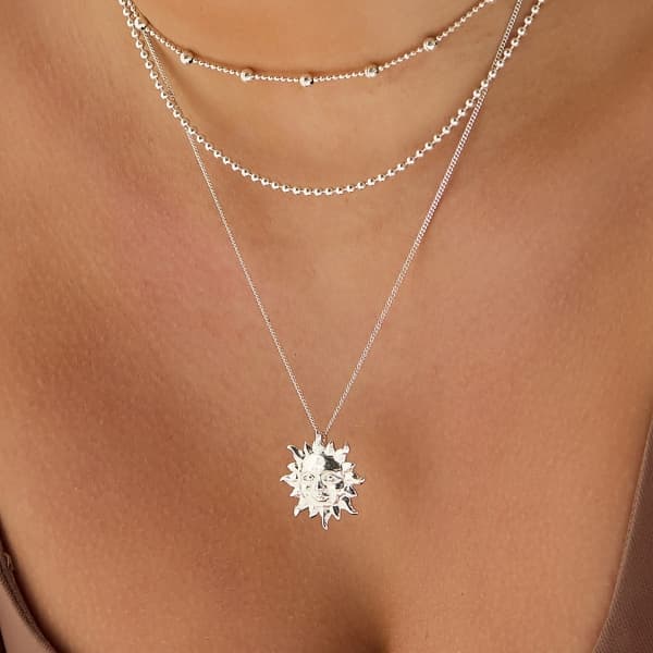 Silver Sun of May Necklace layered with chains