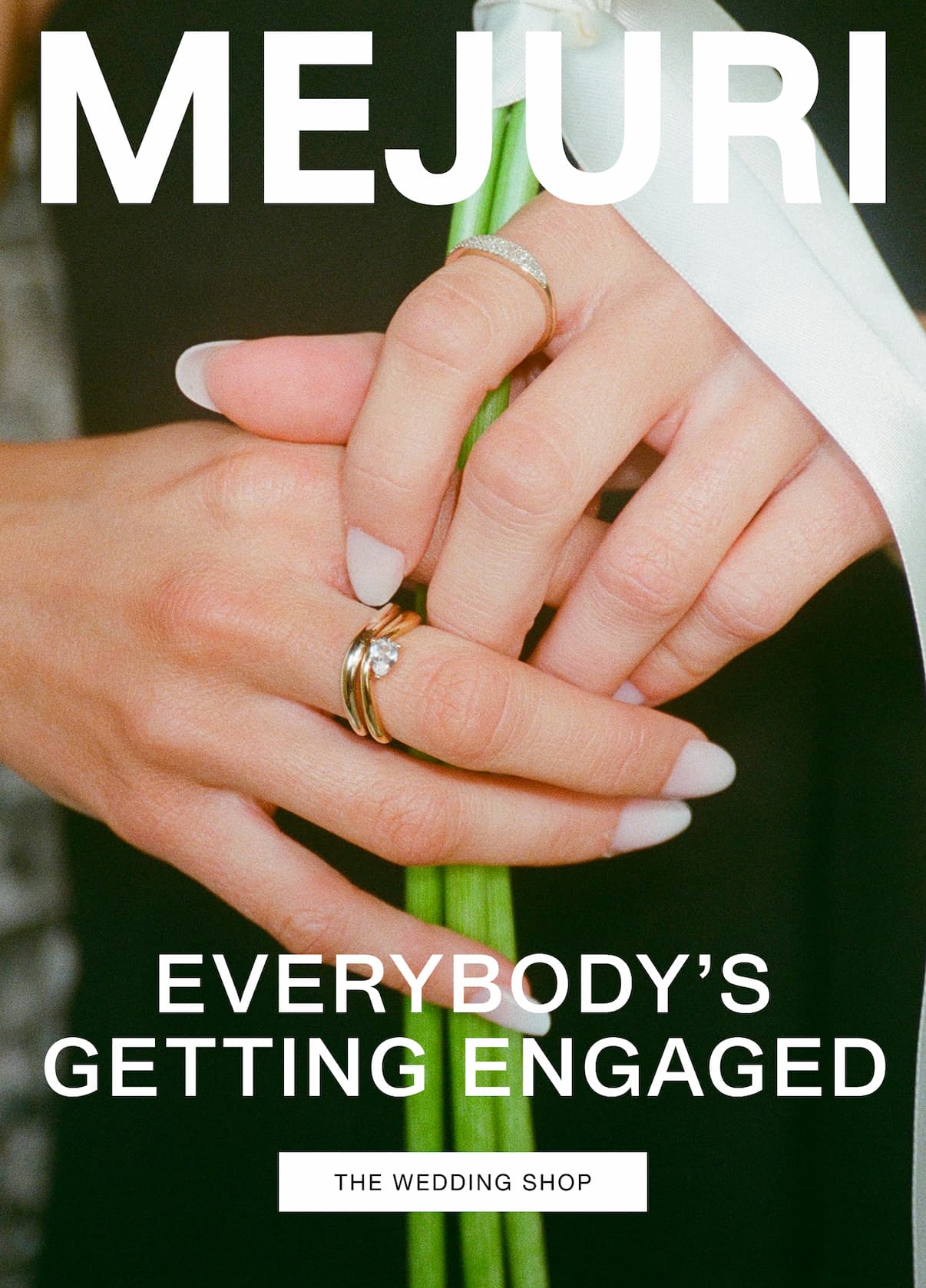 Two hands wearing diamond and gold rings holding a bouquet. Text reads: MEJURI. EVERYBODY'S GETTING ENGAGED. The Wedding Shop.