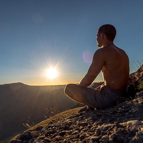 Person meditating on mountain