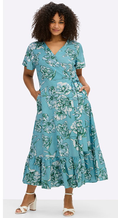 Ein Model trägt ein aquamarin-smaragd-gemustertes Wickelkleid mit Volant am Saum