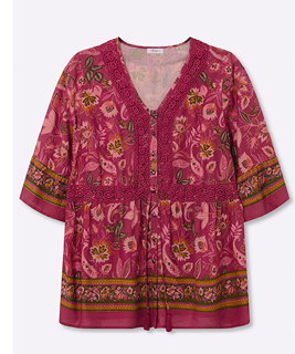 Eine kirsche-flamingo-gemusterte Volantbluse mit floralem Alloverdruck
