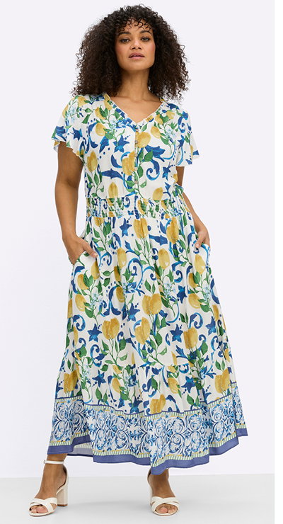 Ein Model trägt ein weiß-sonnengelb-gemustertes Maxikleid mit breitem Smokbund