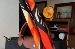 She gives her purse an instant style boost with this clever silk scarf trick