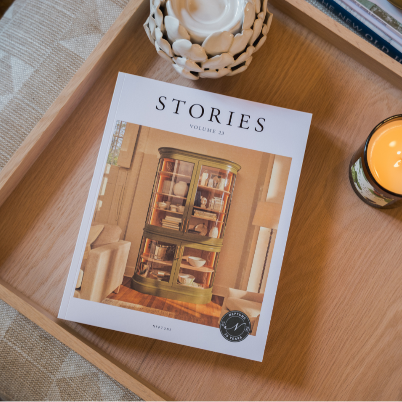 Copy of Stories Volume 23 laid on a tray on top of a footstool next to candle