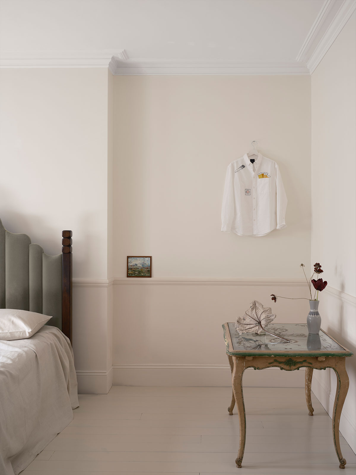 Soft, barely-there neutrals shift subtly across walls and woodwork, using a mix of tones to ground the room’s light and airy feel. Delicate furnishings, a simple bed and vintage table enhance the quiet elegance of the scheme.