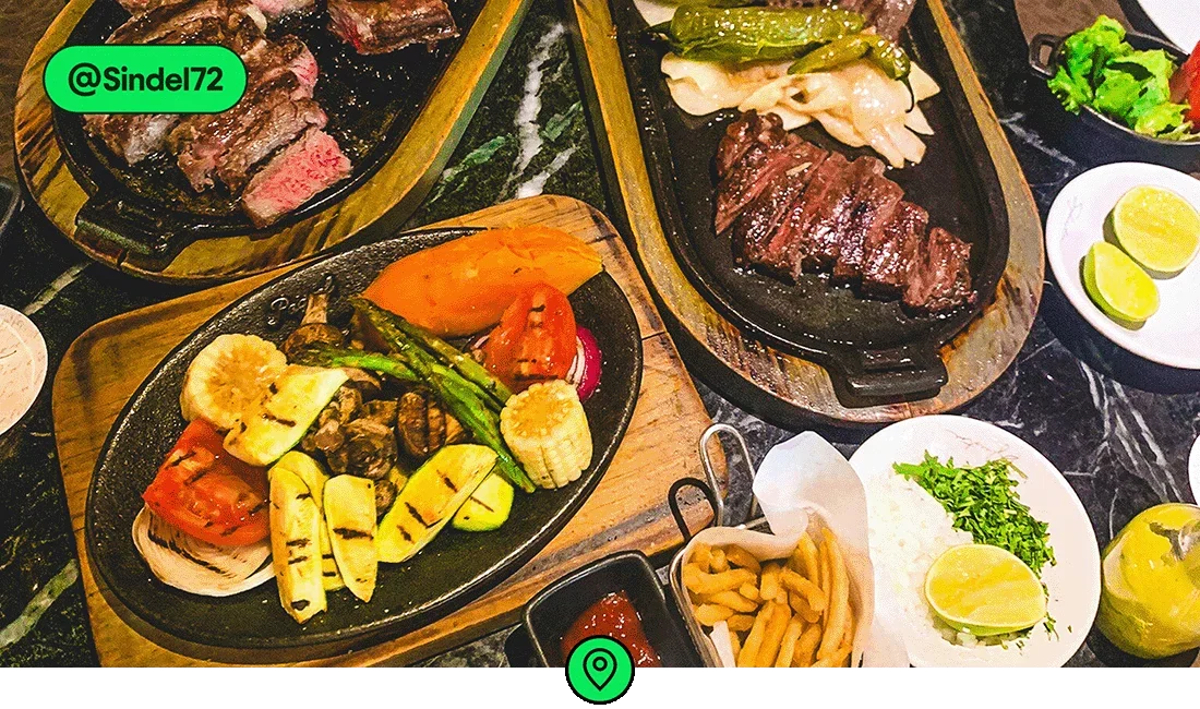 Image description: A table full of grilled meats and vegetables, photo taken by @Sindel72