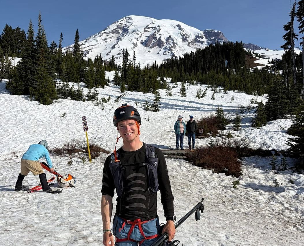 Simon Kearns with poles standing in front of rainier