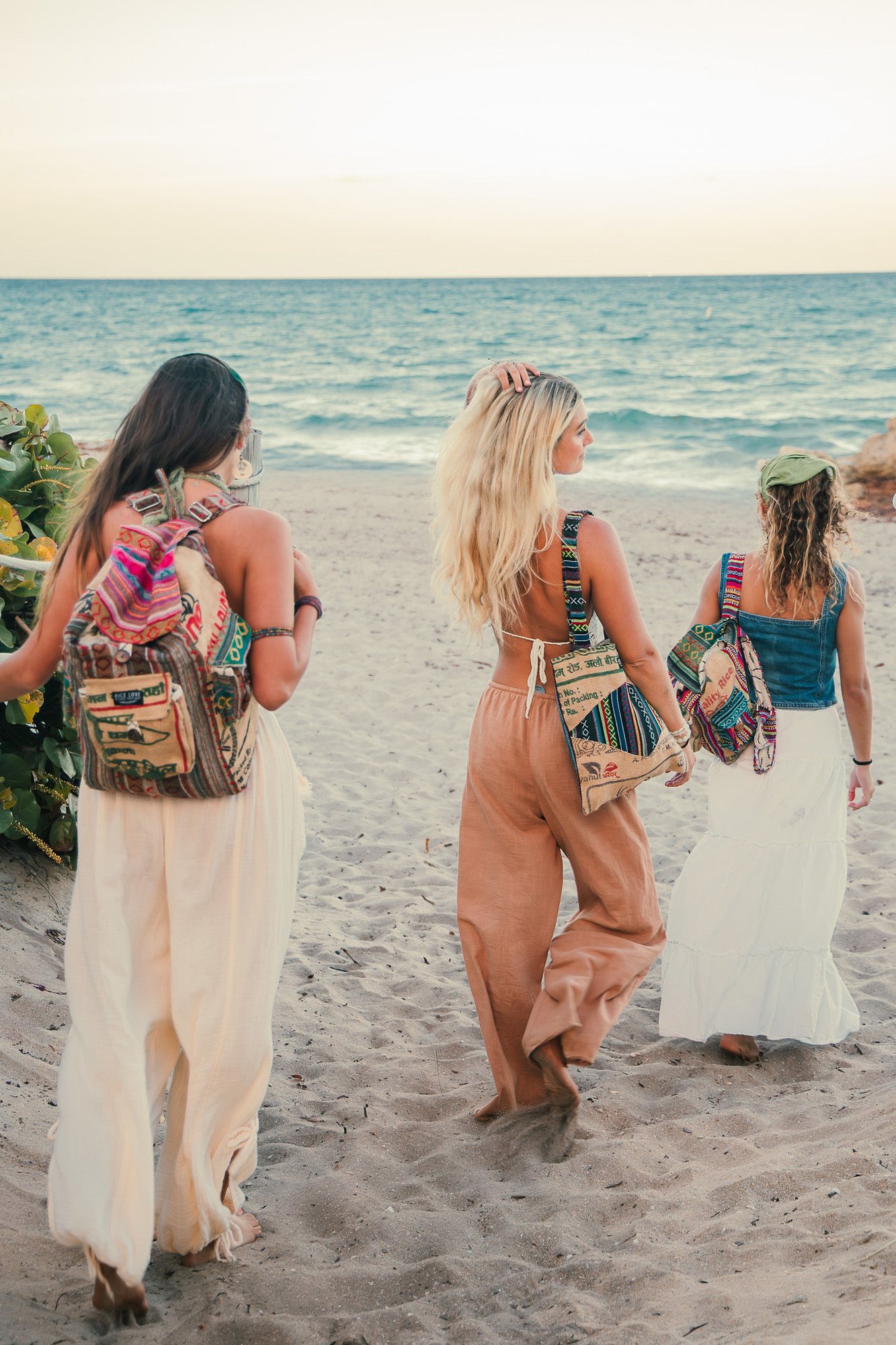 Three woman walking on the beach wearing Rice Love bags