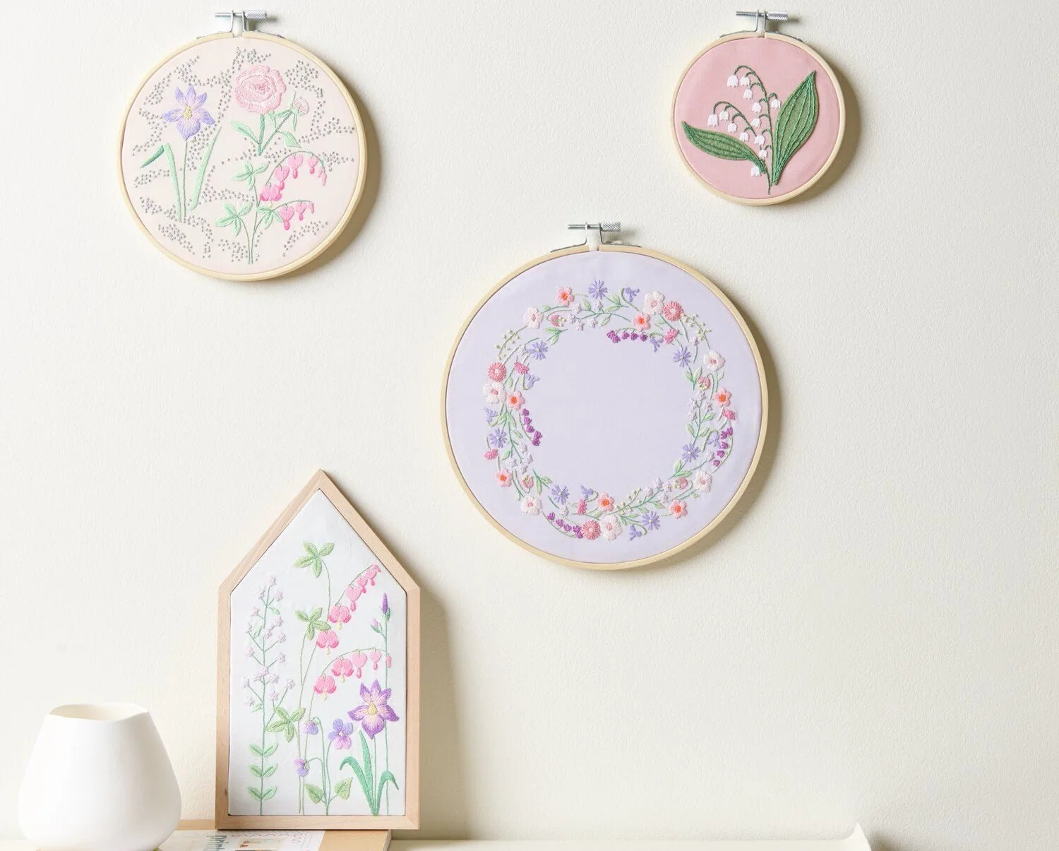 Stickpackungen im Holzrahmen mit Blumenmotiven